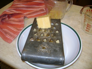 Shredding cheddar cheese.